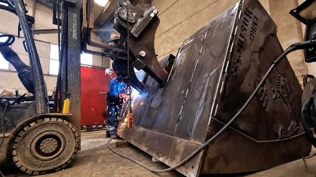 Sudarea unei cupe de excavator în hala proprie